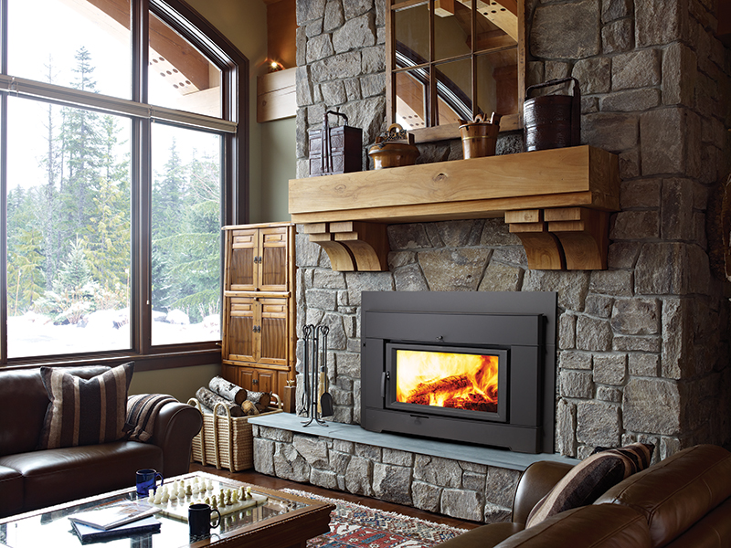 wood stove insert against stone wall in living room overlooking snowy window