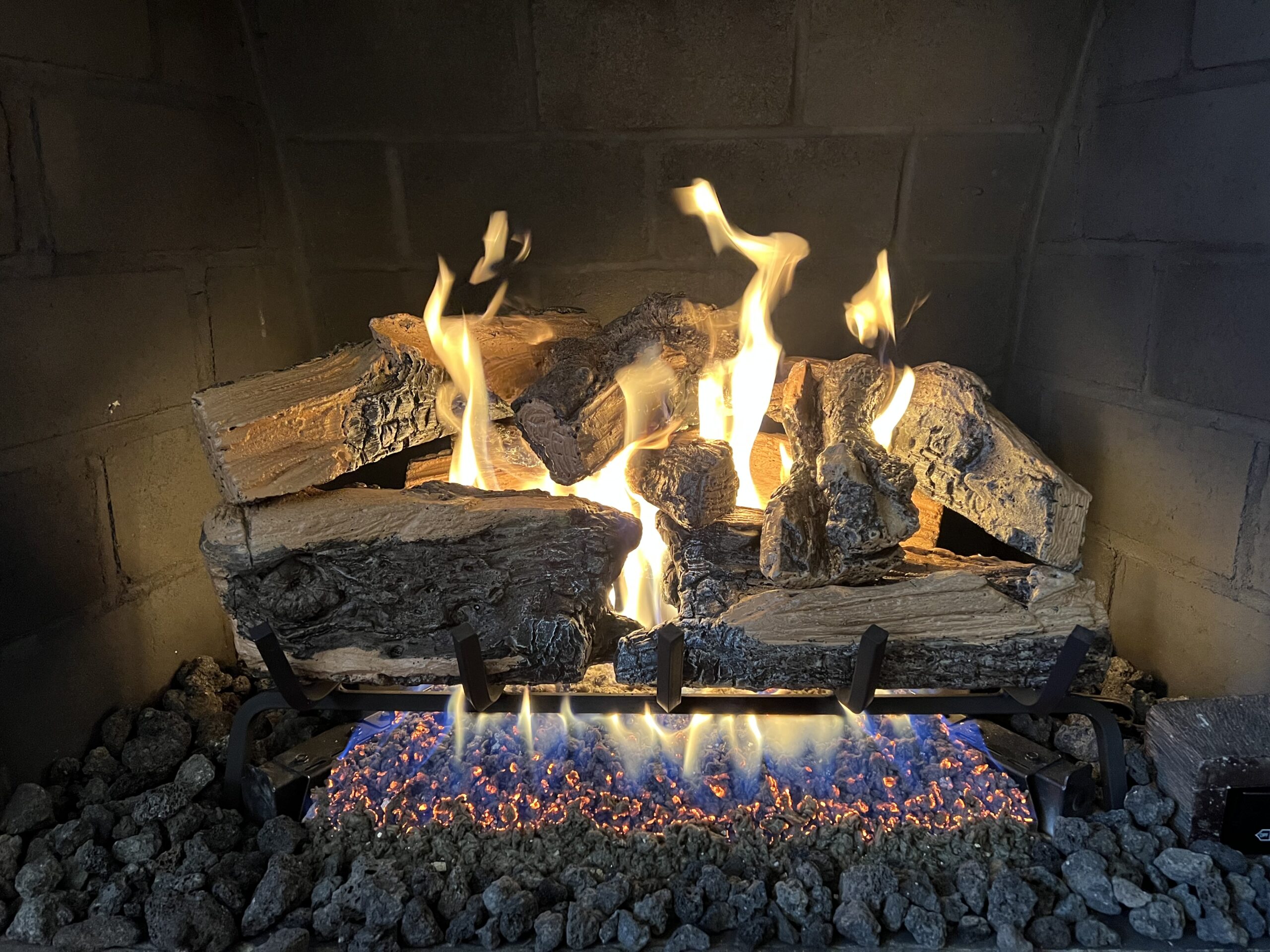 Gas log fireplace set placed above clear decorative rocks