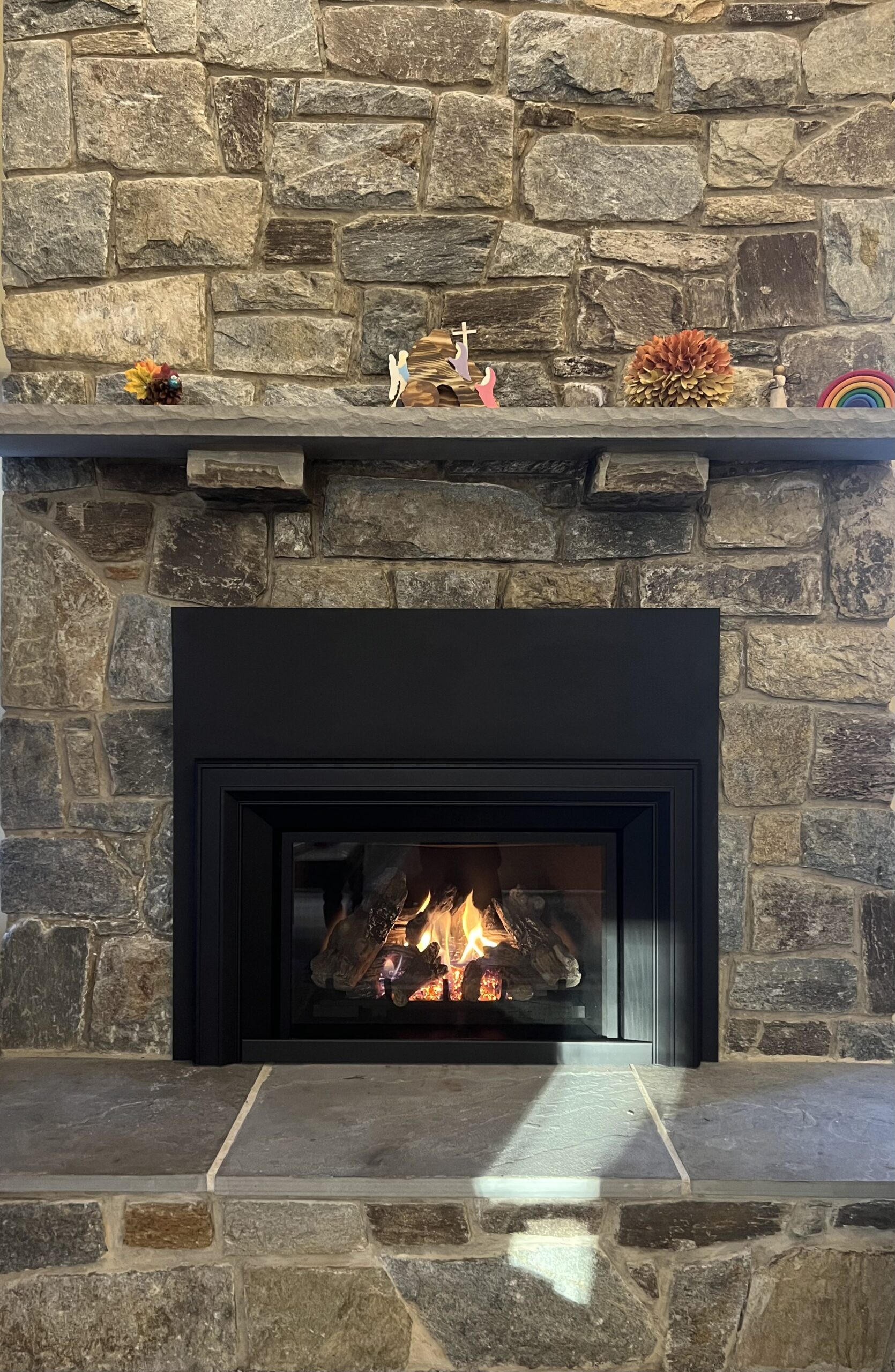 gas fireplace insert in a stone wood fireplace