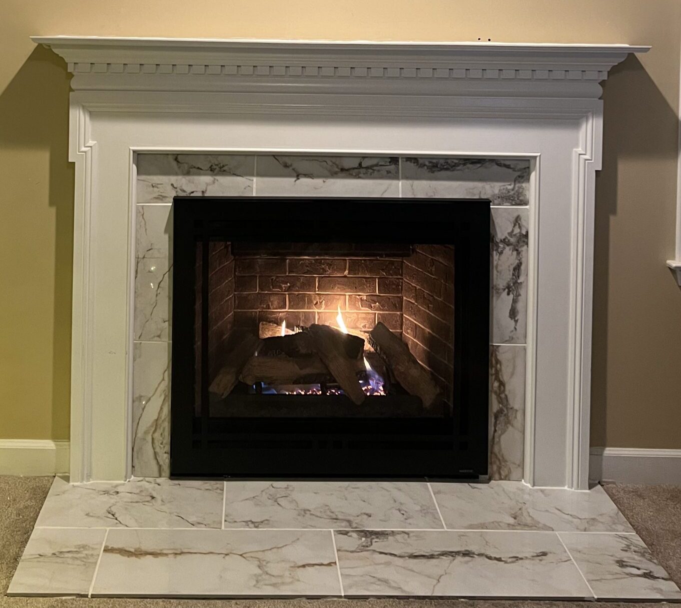 Vented gas fireplace set in a marble designed fireplace